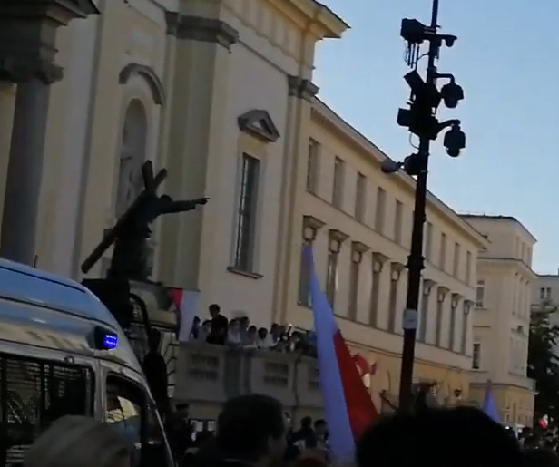 Flaga leżąca na pomniku Chrystusa na Krakowskim Przedmieściu w Warszawie, obecny monitoring miejski (umożliwiający wskazanie sprawcy) oraz obecny radiowóz na miejscu zdarzenia.